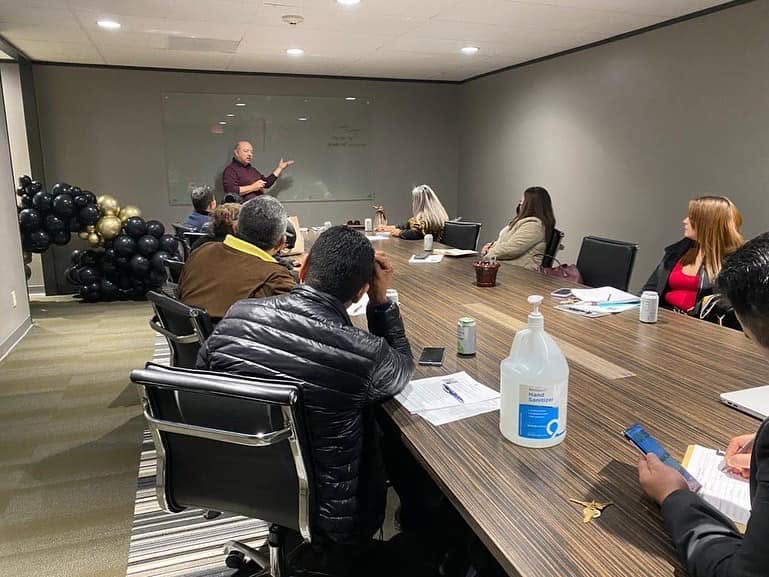 Founder Edwardo Rodriguez briefing professionals around a conference table